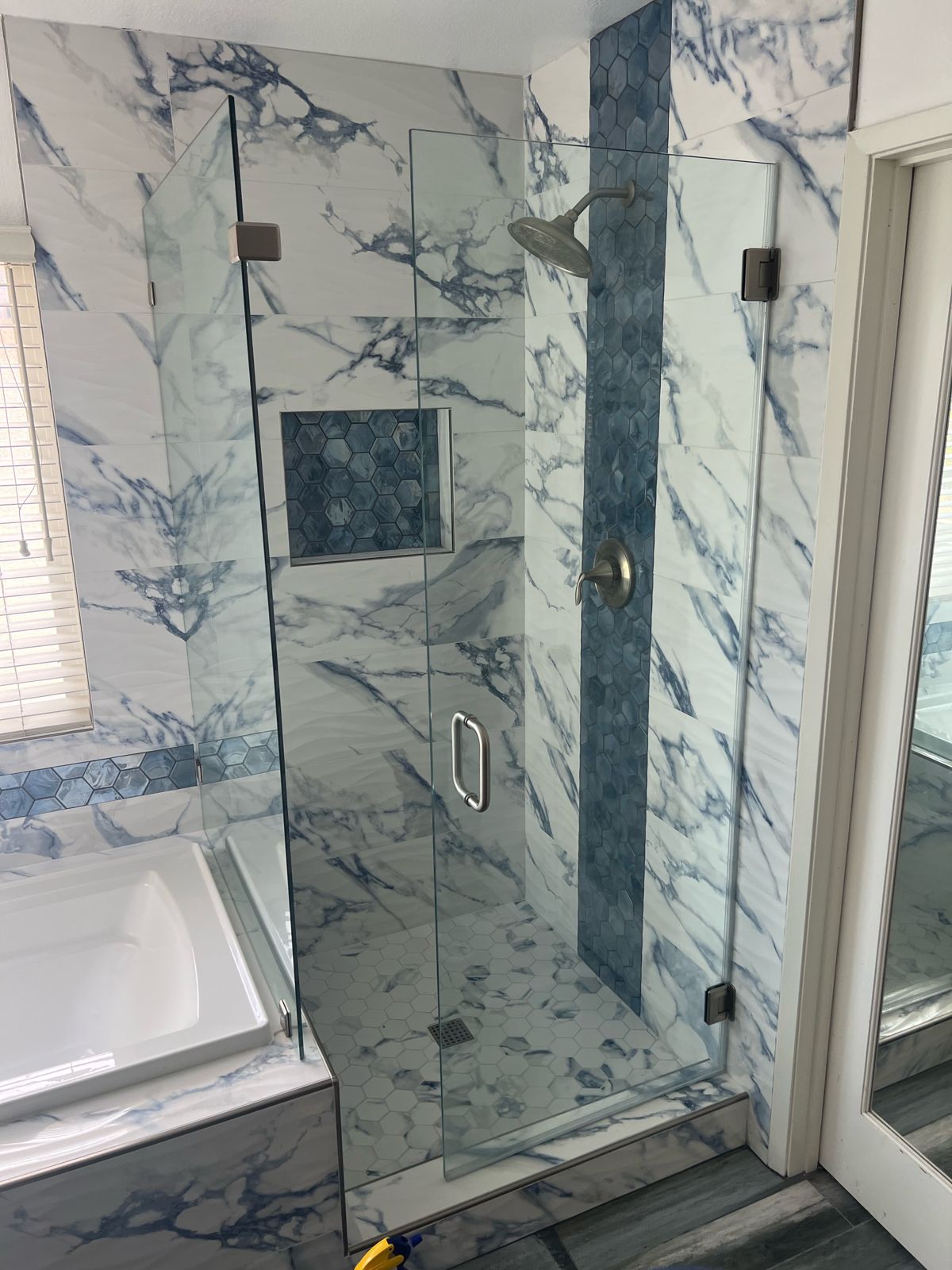 Marble shower with navy hexagon accent